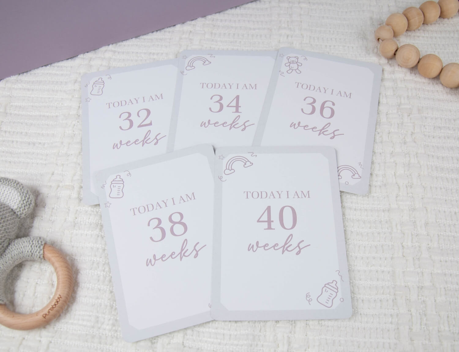five pregnancy milestone cards displaying the number of weeks pregnant