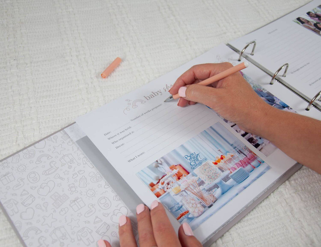 baby shower page in pregnancy journal being filled in