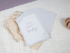 pregnancy milestone card displaying the words we are having a baby